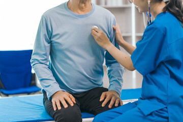 Obraz premium Elderly man engages in thoughtful discussion with compassionate asian people female doctor, addressing health agenda and medical concerns, exemplifying importance of patient-centered care.