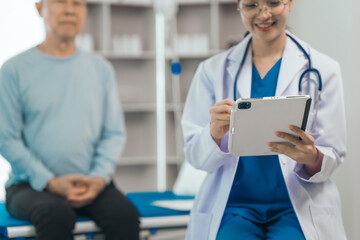 Elderly man engages in thoughtful discussion with compassionate asian people female doctor, addressing health agenda and medical concerns, exemplifying importance of patient-centered care.