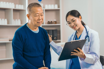 Fototapeta premium Elderly man engages in thoughtful discussion with compassionate asian people female doctor, addressing health agenda and medical concerns, exemplifying importance of patient-centered care.