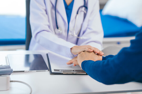 comfort, encourage, Asian people experienced female doctor giving advice to elderly male patient cancer and x-ray results and treatment options, Cancer Consultation, holding hands