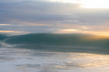 A wall of wave and cloudy sky.