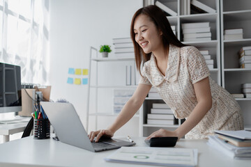 Young Asian woman, businesswoman in finance, businesswoman working in finance, planning finances for a startup company and reviewing financial statements. Financial management concepts.