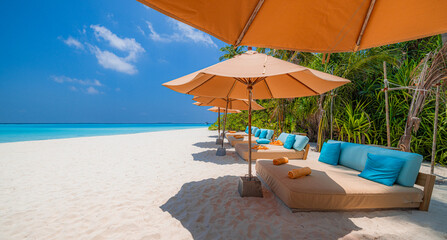 Popular summer holiday and vacation destination. Sunny sea coast umbrellas chairs beach beds coconut palm trees. Luxury travel, best landscape. Tropical paradise island. Exotic seaside calm wellbeing