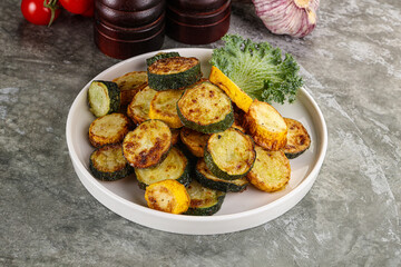Roasted young zucchini in the plate