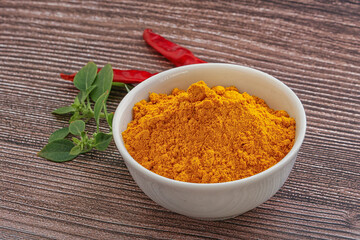 Yellow vibrant curcuma powder in the bowl