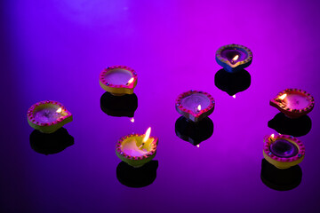 Close up of seven diwali candles with copy space on purple background