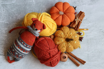Cozy autumn crochet. Close  up photo of handmade amigurumi toys made of natural yarn. Cute decorations for autumn holidays. Hobbies and leisure concept. 