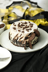Oreo Cheesecake include chocolate, cream, sugar with fork and flowers served in plate isolated on napkin side view of cafe food