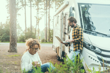 Travel couple adult people man and woman enjoy outdoor leisure activity outside a modern rv vehicle...