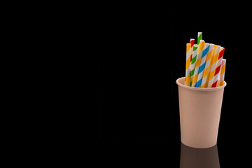 Colorful pattern of paper straws in paper coffee cup isolated on black background with clipping path.