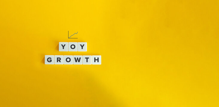 Year Over Year (YOY) Analysis Concept Image. Letter Tiles on Yellow Background. Minimal Aesthetic.
