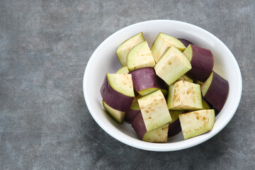 Fresh organic eggplant slice on the white bowl, close up
