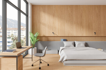 Cozy hotel bedroom interior with bed and workplace, panoramic window