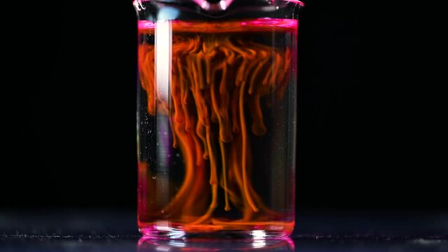 Fluorescent toxic substance dissolving in the chemical solution. The scientist conducts demonstration experiments with solutions. The phenomenon of brownian motion fluorescence.