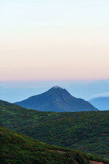 夜明け前の山々の稜線と遠くに霞む山の峰と朝日に照らされて赤くなる空　栃木県那須