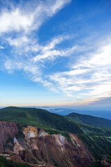 夜明けの朝日に照らされて輝く雲と青空と那須岳のカラフルな地層　栃木県那須