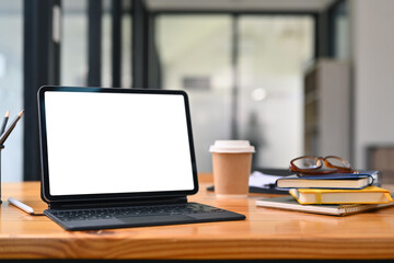 Fototapeta premium Digital tablet, books, glasses and paper cup of coffee on wooden office table