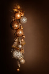 A bunch of New Year's Christmas balls of white gold yellow color on a dark background. Balls hang on a ribbon with a garland.