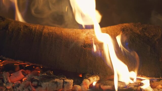 Close-up of burning wood in a fireplace, 4K footage with fire in the fireplace for a background idea or screensaver about home comfort, real-time video