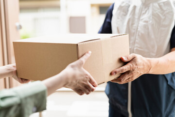 荷物を渡す40代配達員