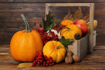 Happy Thanksgiving day. Composition with pumpkins, berries and walnuts on wooden table, closeup