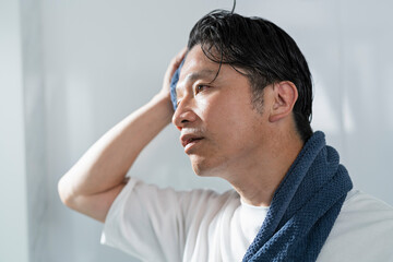 風呂上がりに髪を拭く40代男性