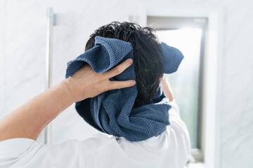 風呂上がりに髪を拭く40代男性