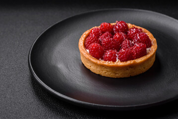 Delicious fresh sweet round tart with ripe raspberries and cream