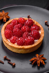 Delicious fresh sweet round tart with ripe raspberries and cream
