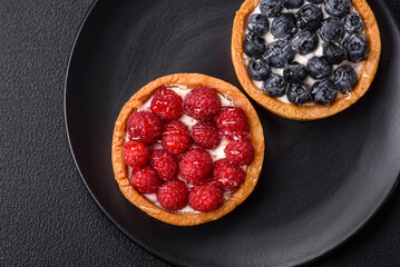 Delicious fresh sweet round tart with ripe raspberries and cream