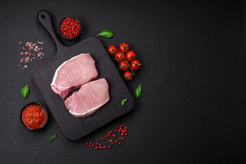 Raw fresh pork meat steak with salt, spices and herbs