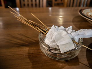 Several collections of skewers in a cigarette ashtray on the dining table
