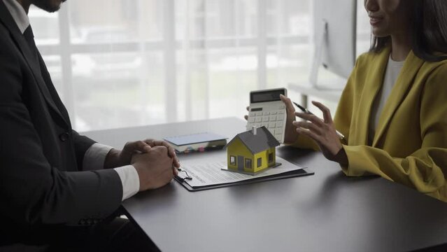 Real estate agents offer price lists and conditions for buying houses and real estate. An employee introducing a sample housing project is bidding on a housing project to a customer.