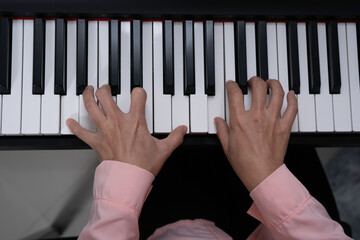 Top view of woman hand pressed on paino keyboard, playing paino, artist practicing music.