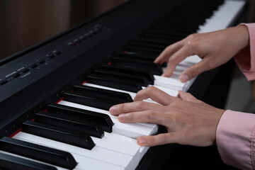Obraz premium Close up senior woman hand with frickle playing electronic paino at her home, relaxing time with music, practice music, learning music at home concept.