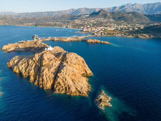 Aerial view of La Pietra lighthouse and island at Ile Rousse in Corsica - 654747716