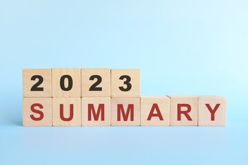 Year 2023 review and summary concept. Wooden blocks typography in blue background. - obrazy, fototapety, plakaty