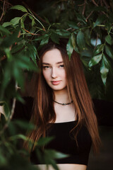 beautiful young woman posing in dark green foliage, girl face on summer nature, beauty and fashion concept