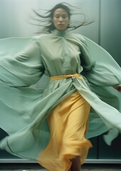 attractive girl running down the street in a pastel mint orange dress, motion blur effect, very short shutter speed, blurry flowing cloak fabric, modern minimalist