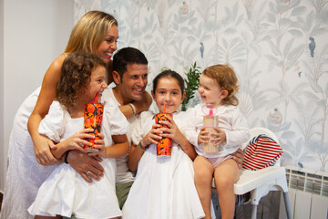 Family smiling happily in the kitchen with their cheerful daughters