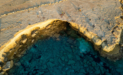 Done scenery of Cape Greko sea caves Ayia Napa Cyprus. Tourist people doing sightseeing and swimming.