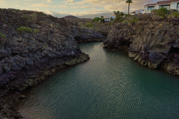Naklejka premium El Charco de Archiles near Amarilla Golf in San Miguel de Abona. Tenerife. It is a natural pool that is filled with sea water. A splendid stone daisy is located on one of its slopes