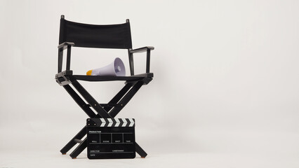 Black director chair and black clapper board with yellow megaphone on white background