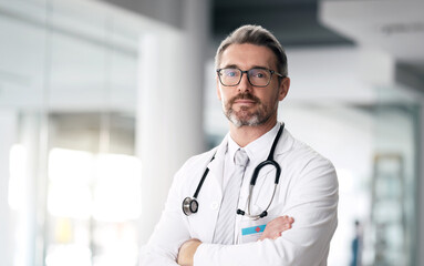 Serious doctor, portrait and man with arms crossed in hospital for healthcare, wellness or career....