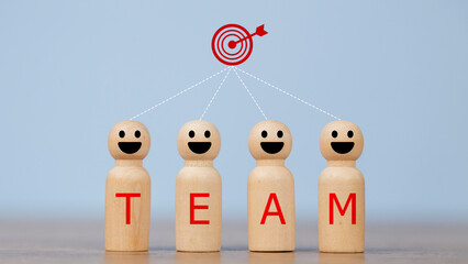 Wooden figures smile faces with team wording on the body and target icons. Teamwork and Ideas for...