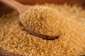 Brown sugar falling down, wooden spoon