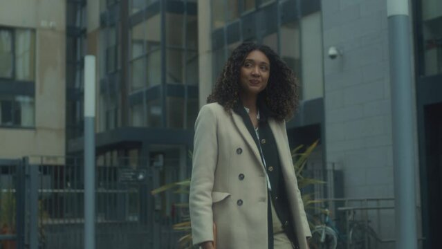 confident business woman walking outside corporate buildings. smiling independent female executive enjoying successful corporate career 4k footage