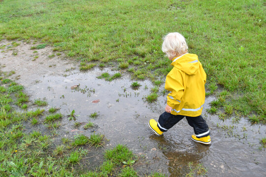 Child going through puddles on a rainy day