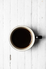 Hot Americano coffee in a white coffee cup placed on a white wooden table The atmosphere is comfortable and refreshing.