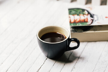 Hot Americano coffee in a white coffee cup placed on a white wooden table The atmosphere is comfortable and refreshing.